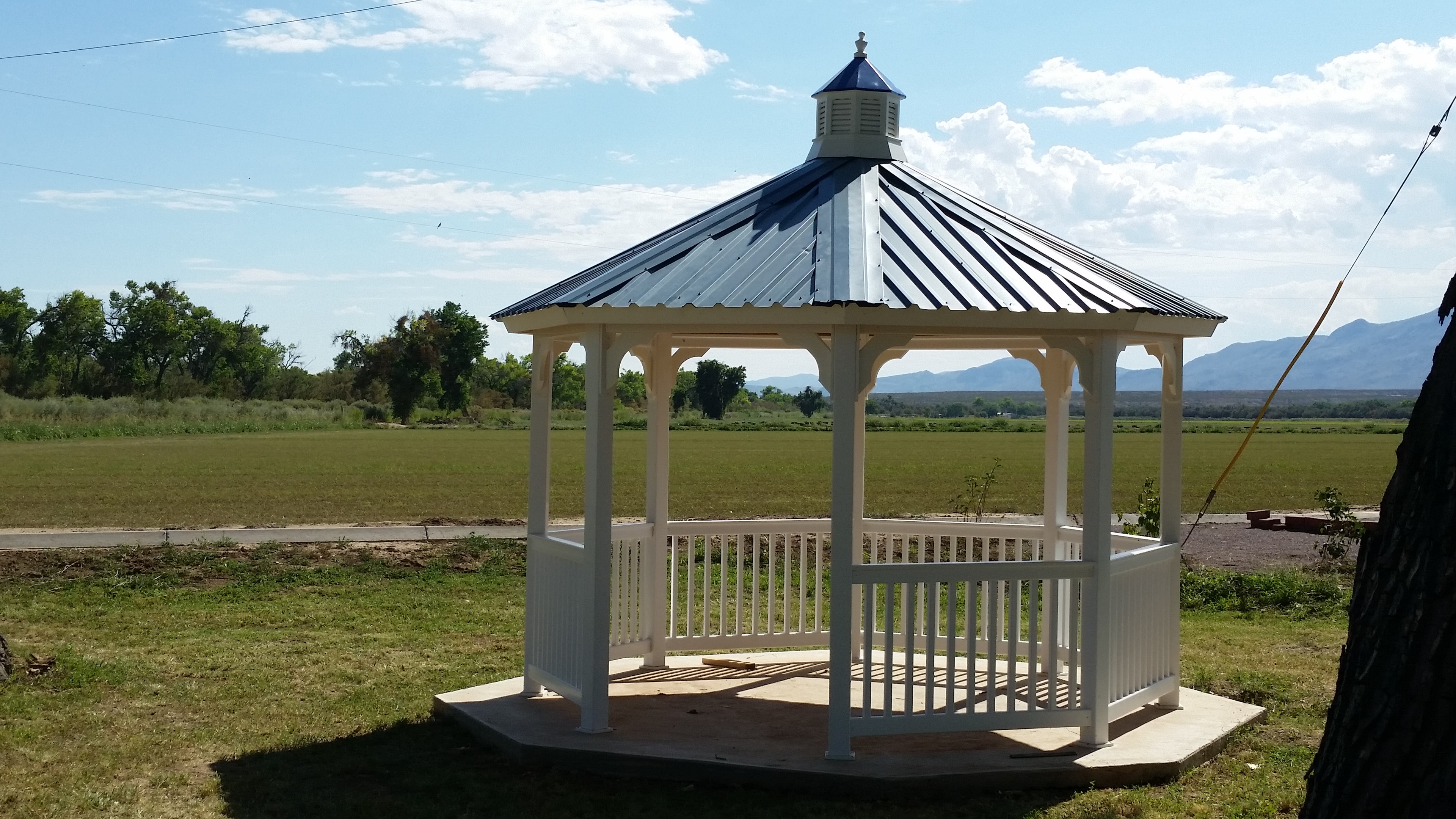 Finished white gazebo with a metal roof in the New Mexico landscape