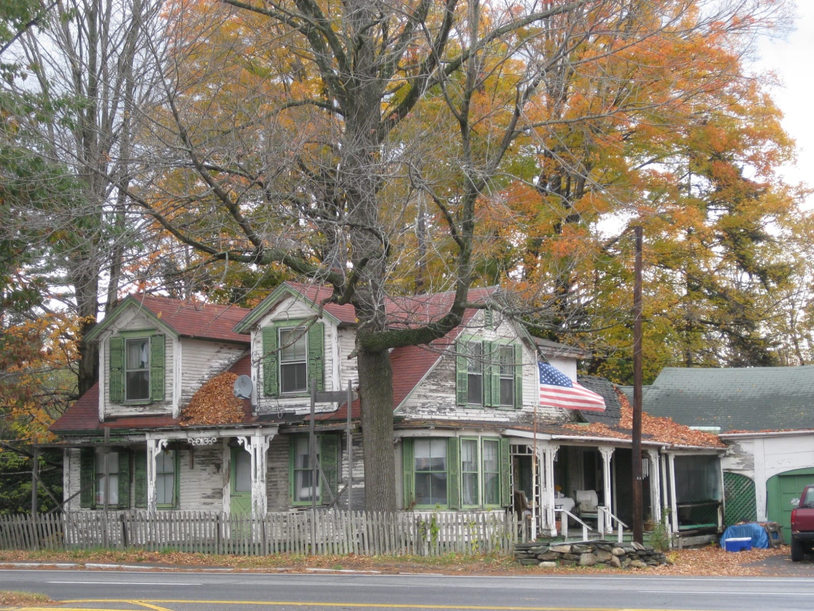 Vermont farmhouse beneath autumn trees