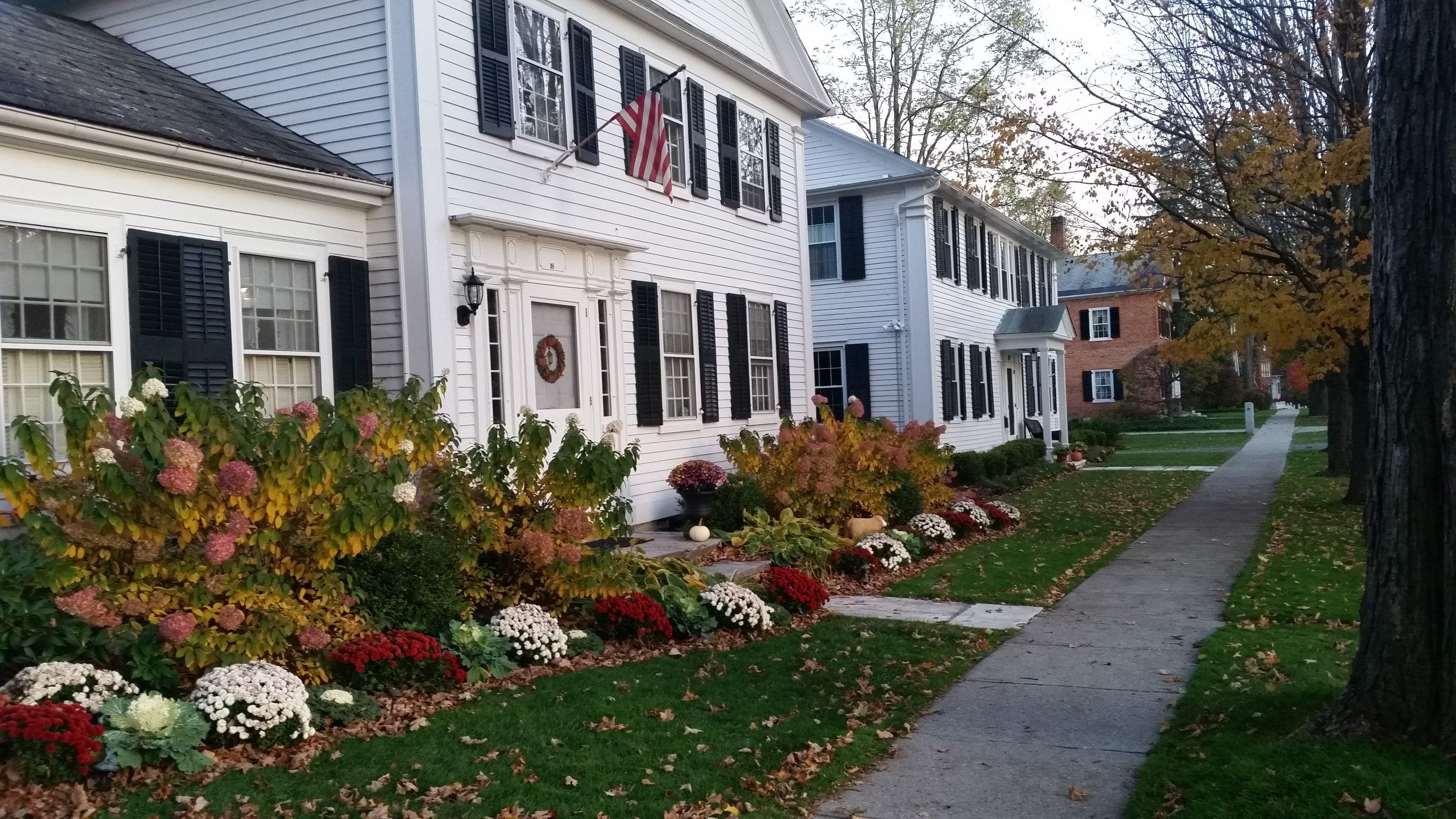 Historic white Vermont home with an autumn garden