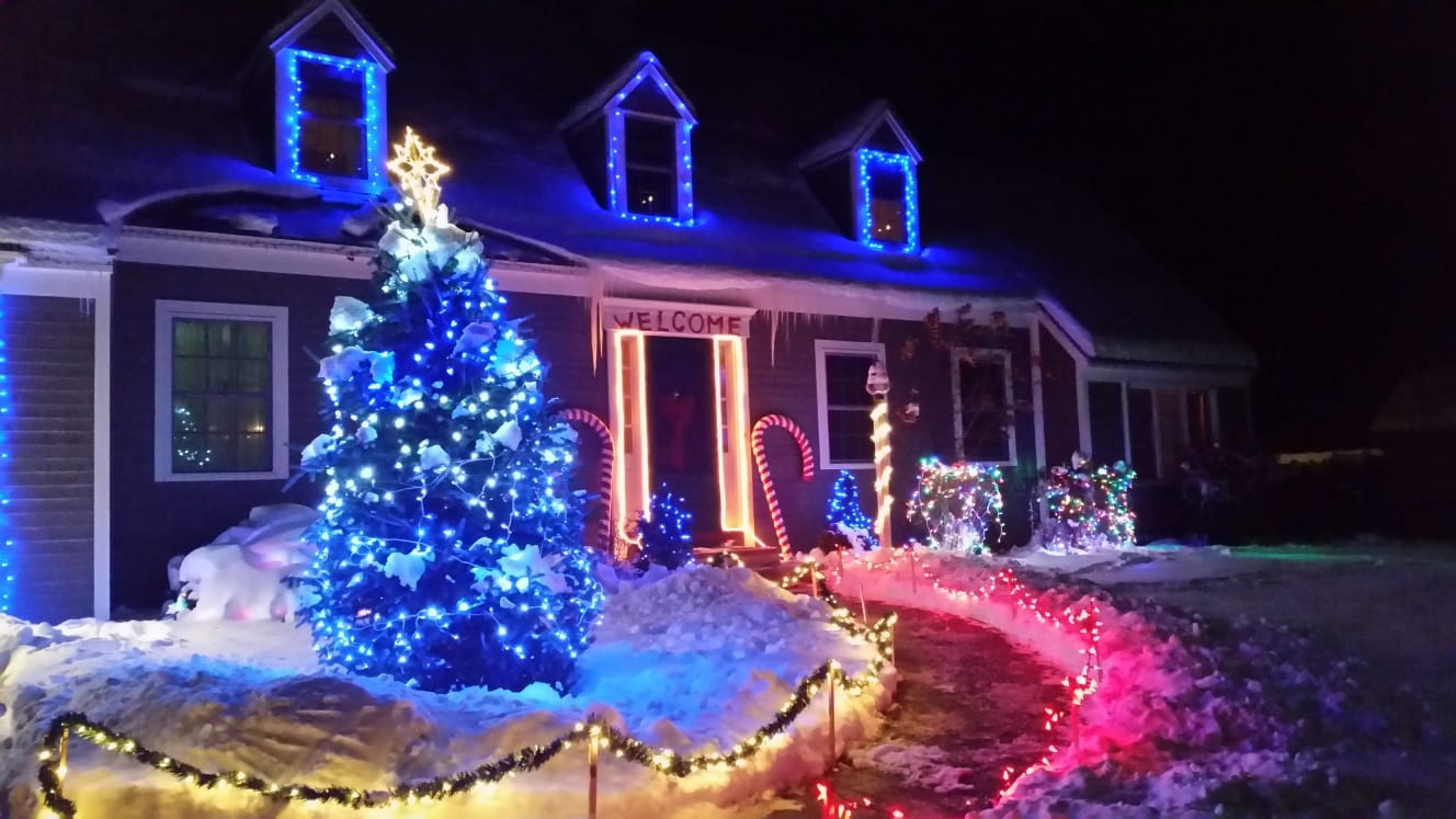 Snow-covered Vermont home with a brightly lit Christmas tree