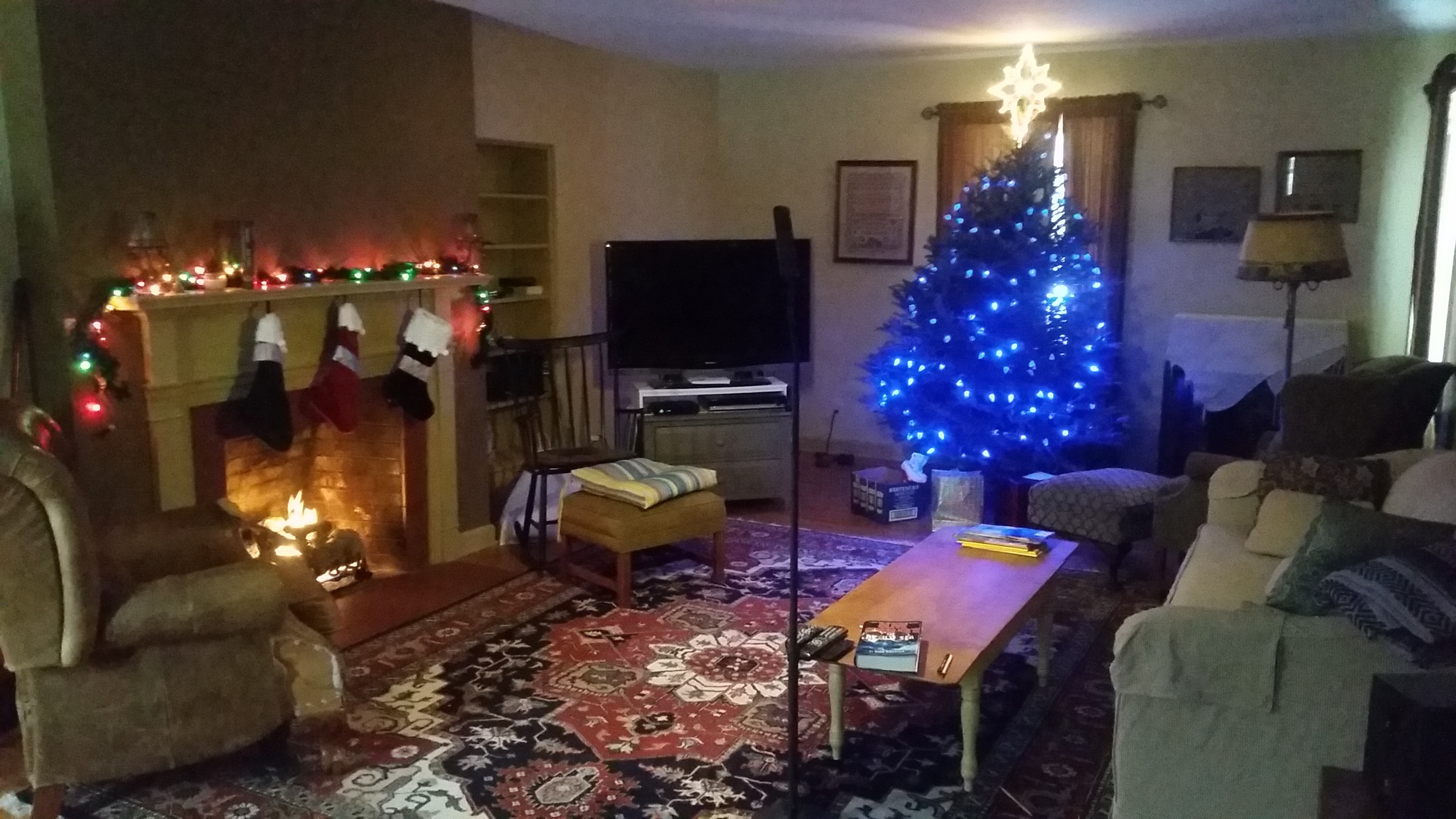 Vermont living room decorated with a Christmas tree, stockings, and fireplace lights