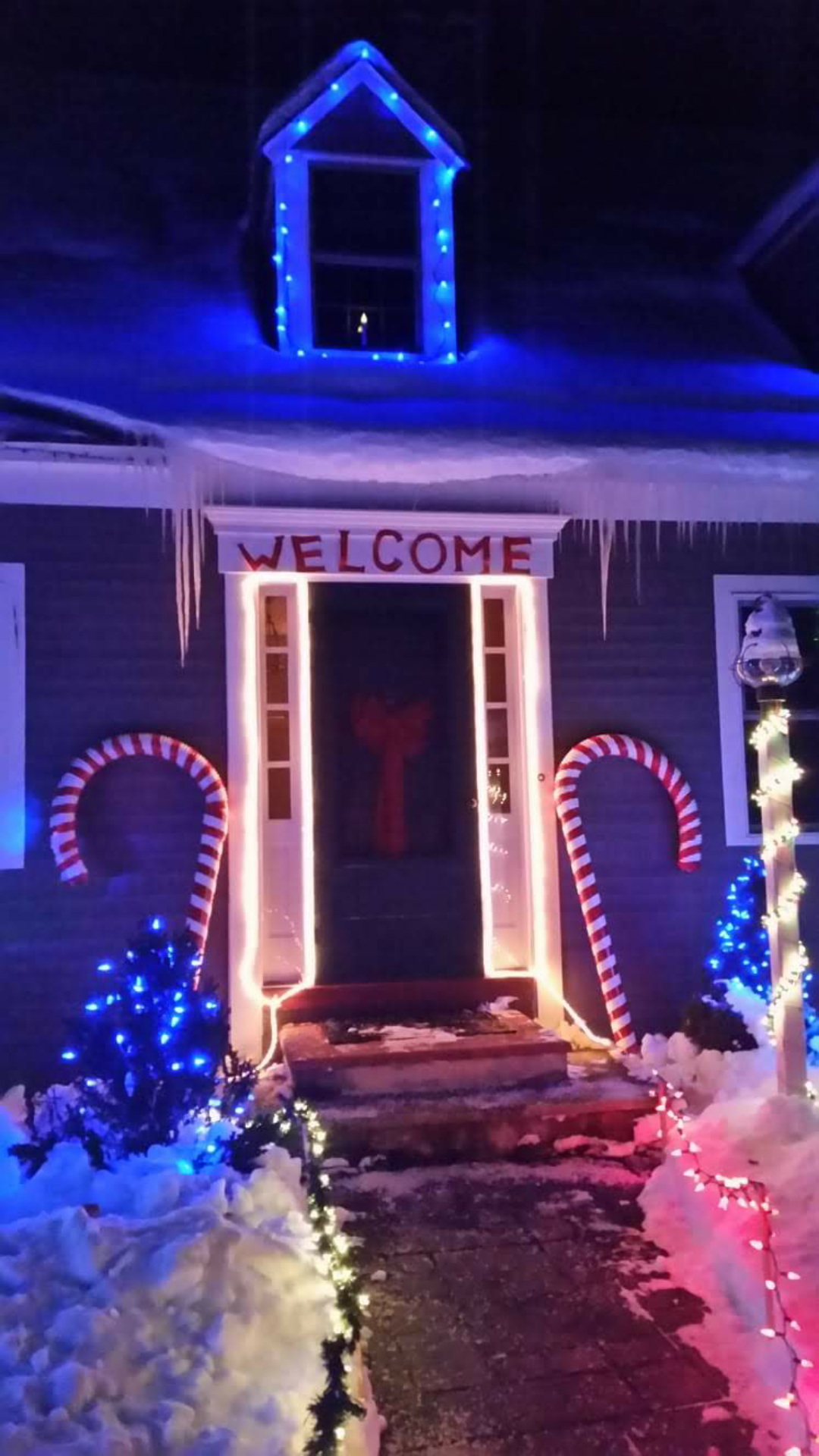 Snowy Vermont home entrance decorated with Christmas lights